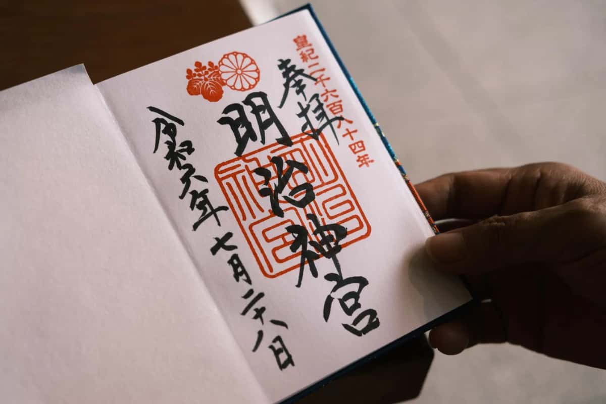 Calligraphie japonaise au pinceau et sceau vermillon dans un carnet de goshuin
