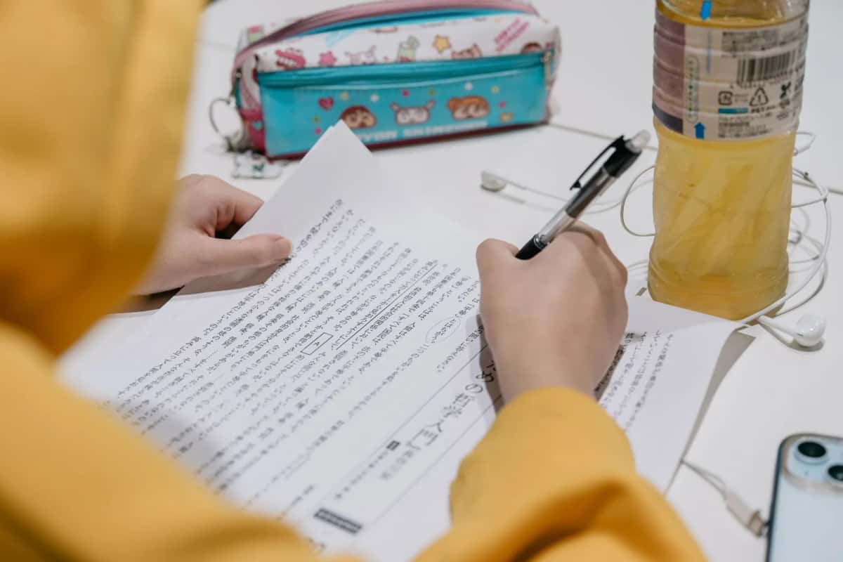Étudiante travaillant sur une feuille d'exercices de japonais écrite en colonnes verticales