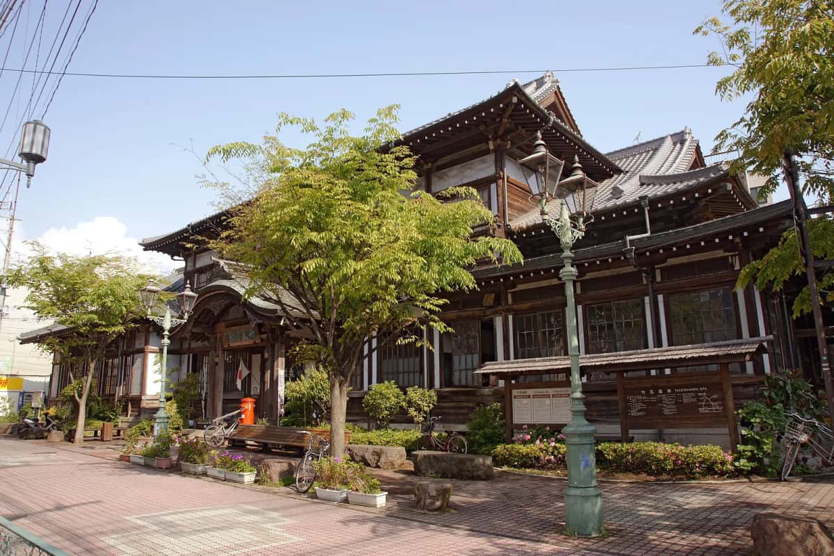 La façade en bois et le toit à pignons de Takegawara Onsen, bain public de 1938 près de la gare de Beppu