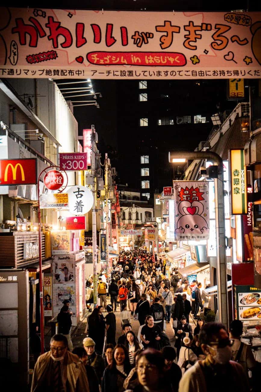 Rue commerçante bondée de Harajuku à Tokyo la nuit, avec enseignes et prix en yens