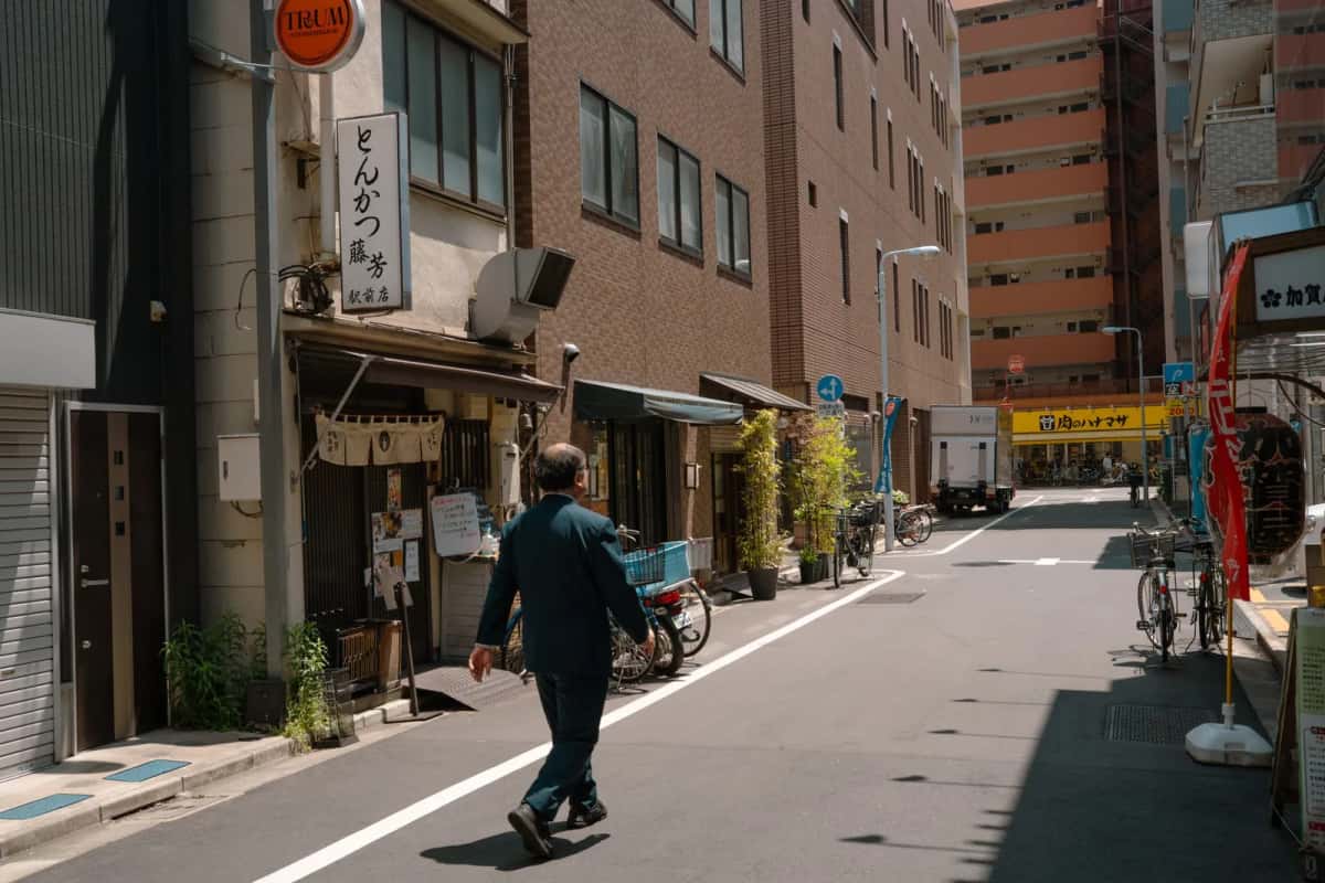 Employé en costume dans une rue commerçante de Tokyo