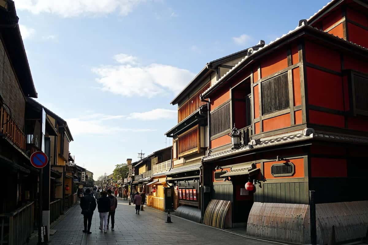Hanamikoji-dori à Gion : maisons de thé en bois rouge et lanternes le long de la rue pavée