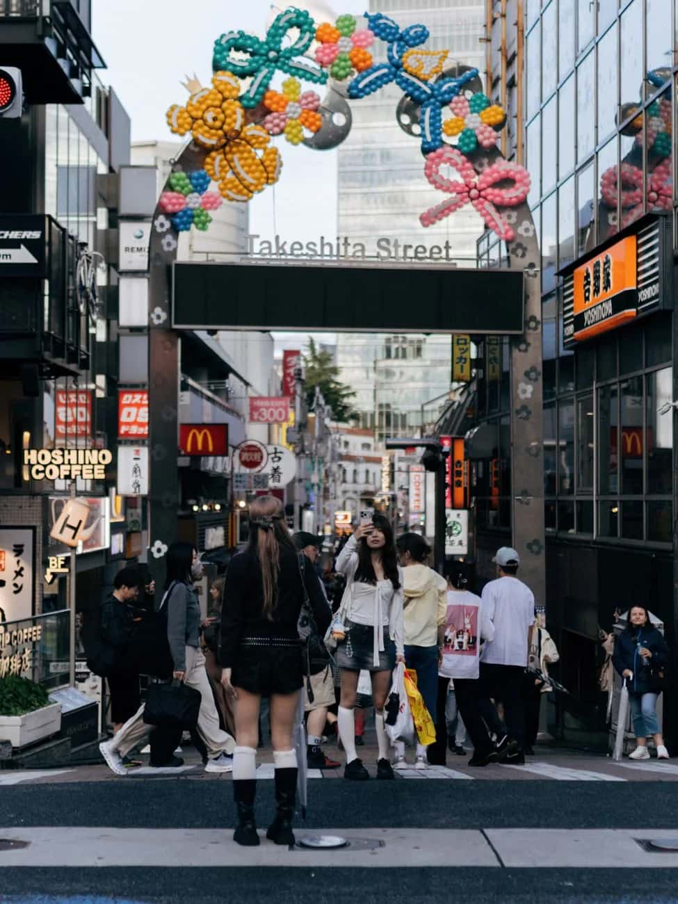 Portique en ballons de Takeshita Street à Harajuku, avec des passantes sur le passage piéton