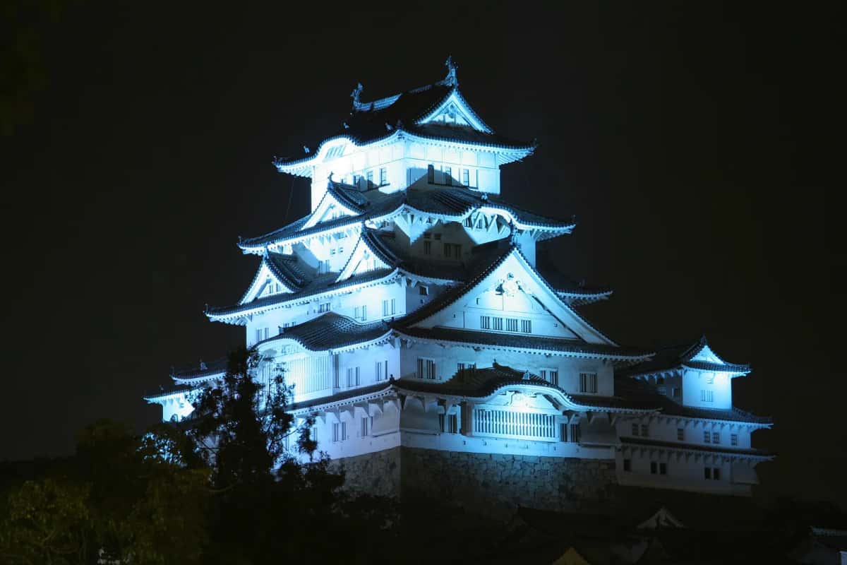 Le château de Himeji éclairé en blanc dans la nuit