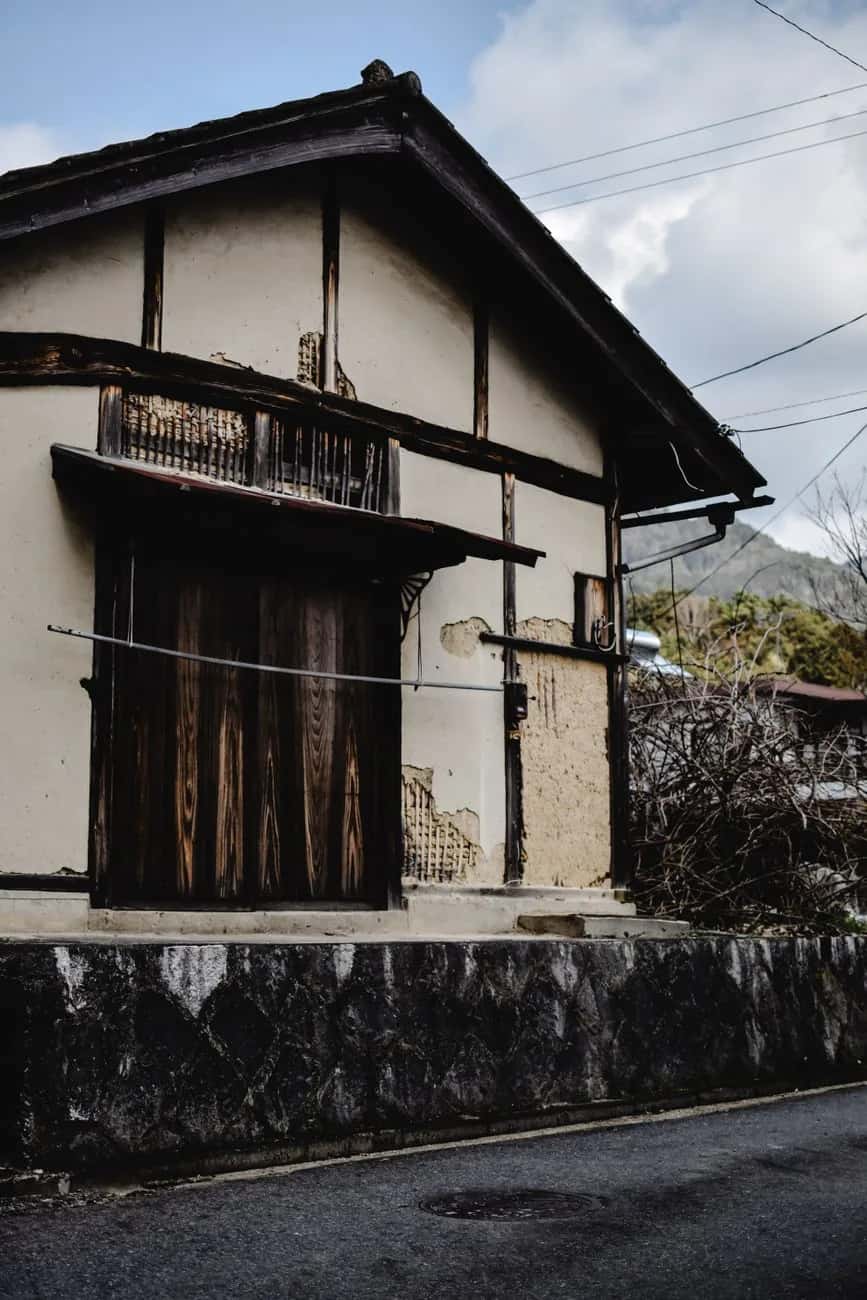 Maison traditionnelle japonaise abandonnée aux murs fissurés, dans un village de la préfecture de Kyoto