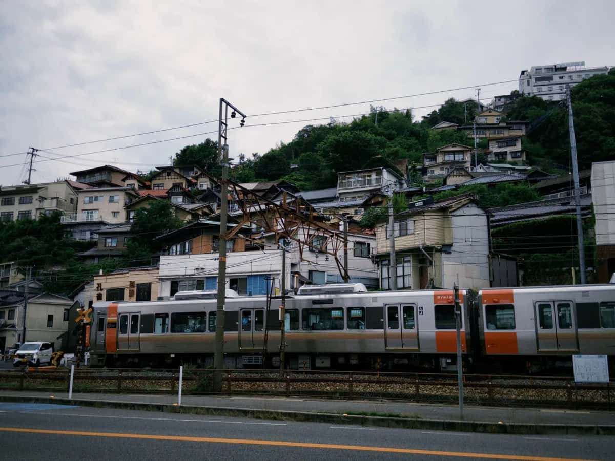 Train régional JR West (série 227) traversant une ville à flanc de colline dans la région de Setouchi, Japon