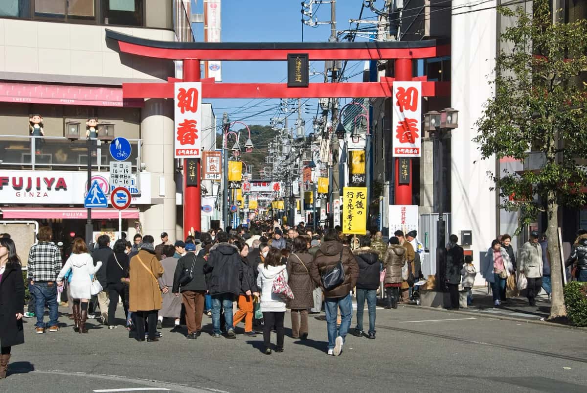 Le torii rouge et la foule à l'entrée de la rue commerçante Komachi-dori à Kamakura