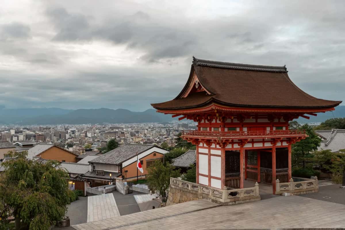 La porte Nio-mon vermillon de Kiyomizu-dera, dominant les toits de Kyoto au lever du jour