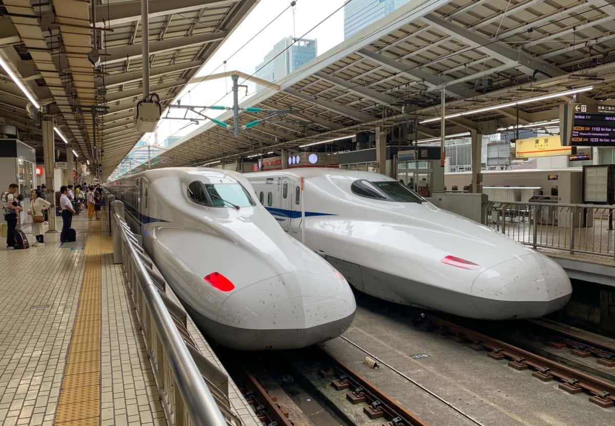 Nez allongés de deux Shinkansen à quai dans une gare japonaise, en direction de Hakata