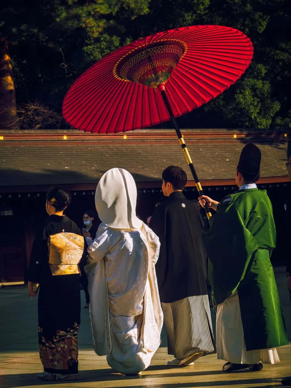 Cortège de mariage shinto sous une ombrelle rouge dans la cour du Meiji Jingu à Tokyo
