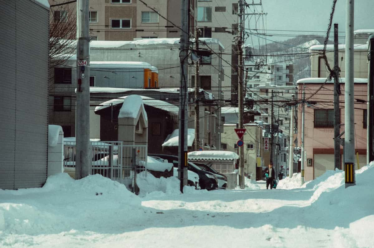 Rue résidentielle japonaise sous une épaisse couche de neige en hiver, typique de Hokkaido