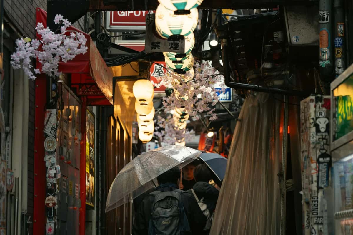 Parapluies transparents dans une ruelle de Tokyo sous la pluie