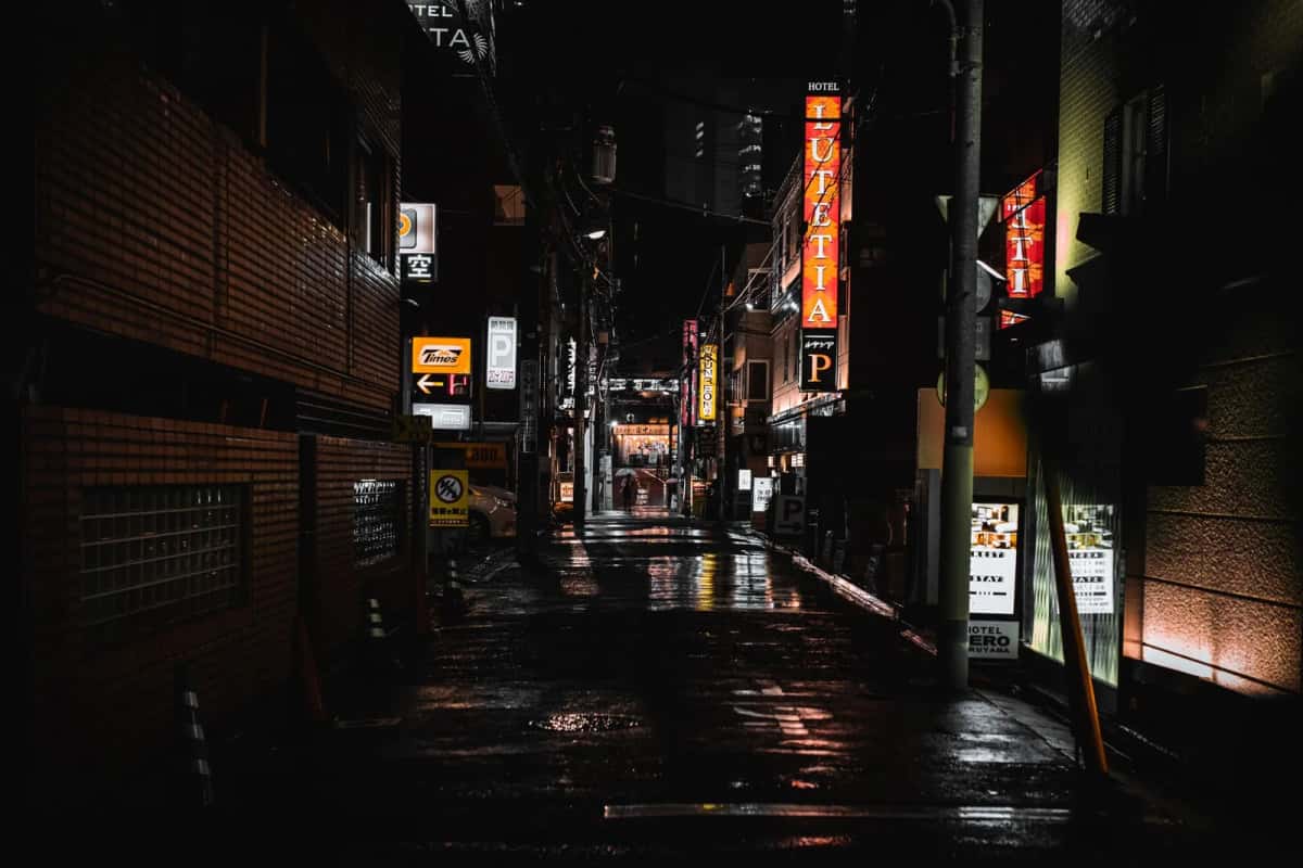 Ruelle de Tokyo mouillée par la pluie, éclairée par les enseignes au néon la nuit