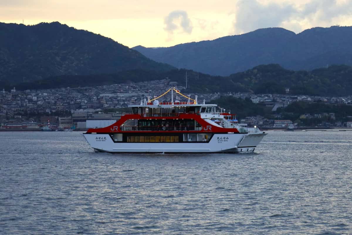 Ferry JR West rouge et blanc naviguant vers Miyajima sur la mer intérieure de Seto