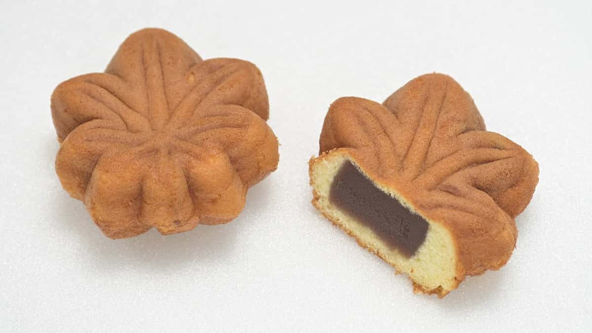 Gâteaux momiji manju en forme de feuille d'érable, l'un coupé pour montrer la pâte de haricots rouges