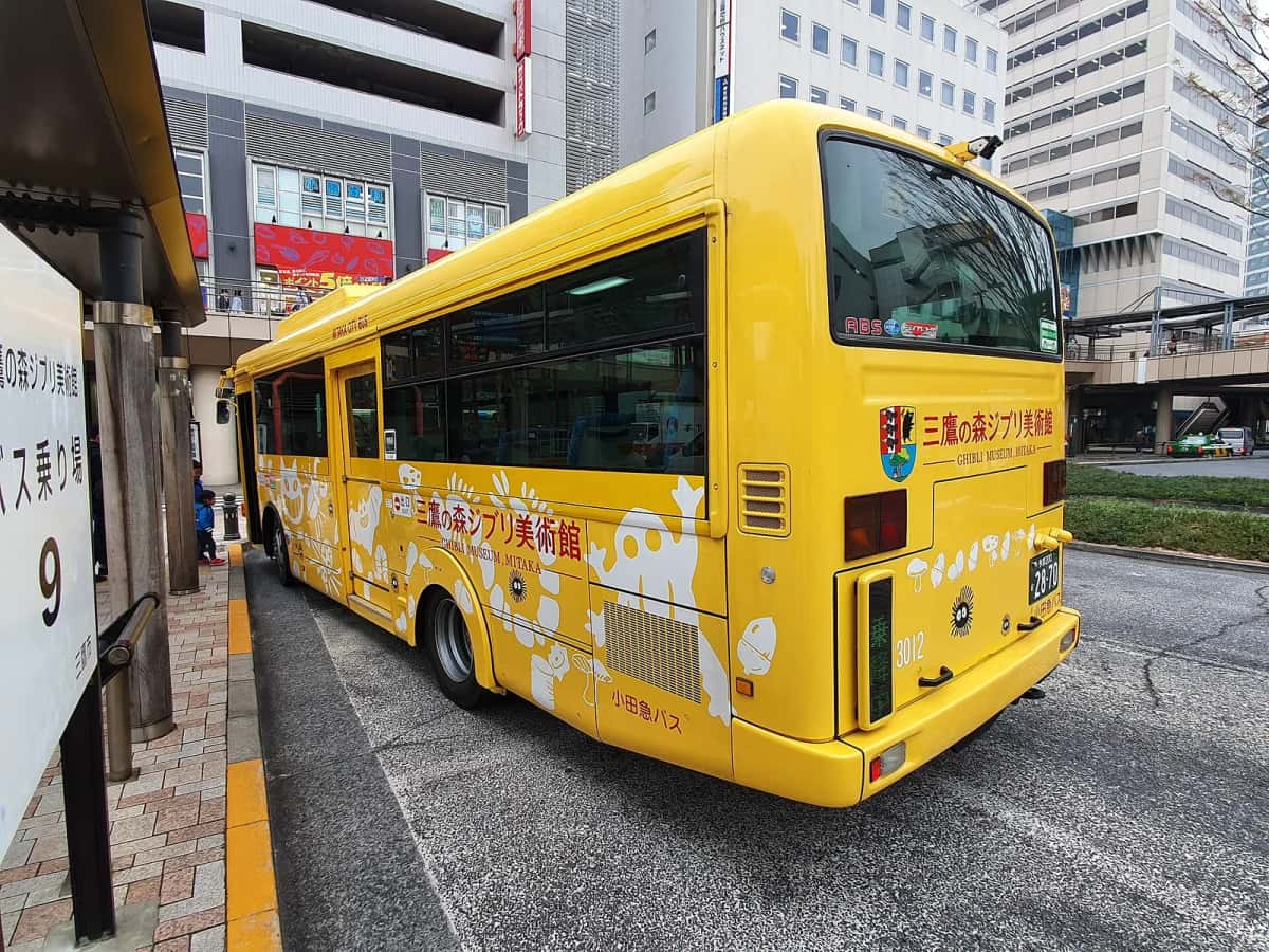Bus communautaire jaune de Mitaka à destination du musée Ghibli, à l'arrêt devant la gare de Mitaka
