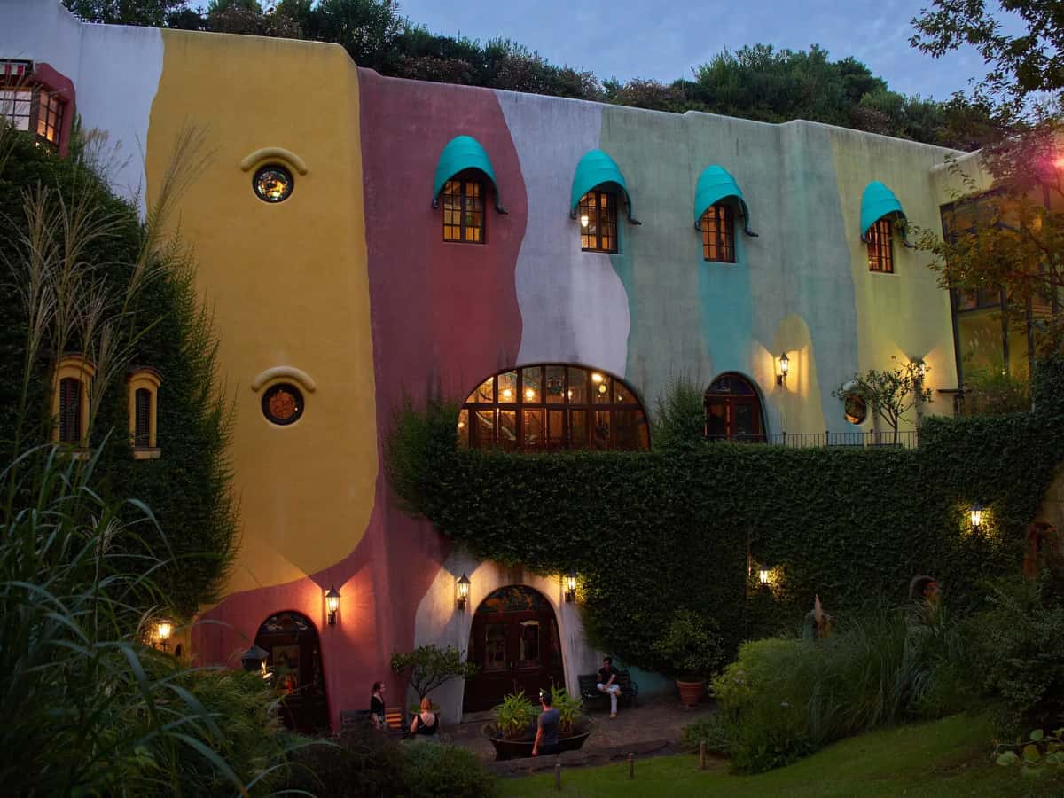 Façade colorée du musée Ghibli à Mitaka, couverte de lierre, avec ses fenêtres rondes et ses auvents turquoise