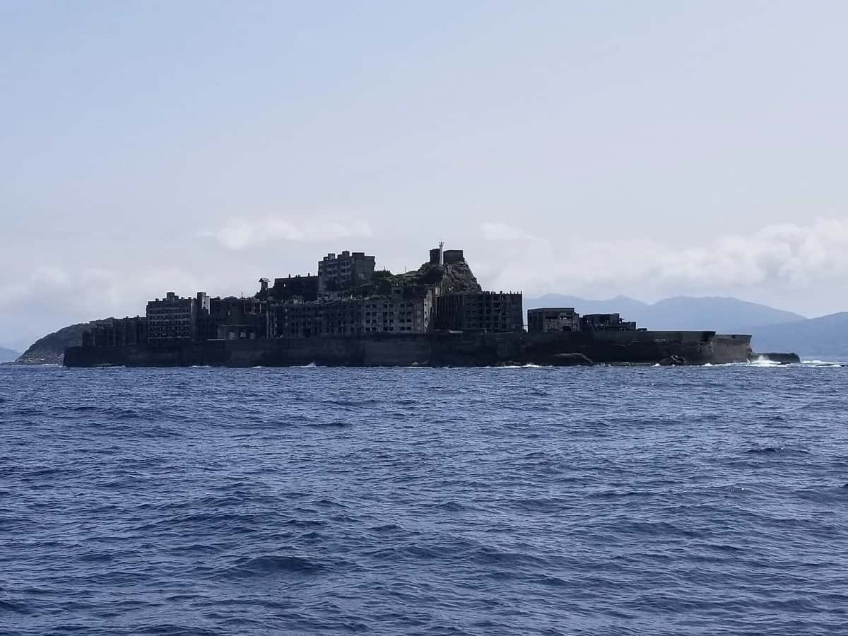 L'île de Hashima (Gunkanjima) vue depuis la mer, silhouette sombre en forme de cuirassé