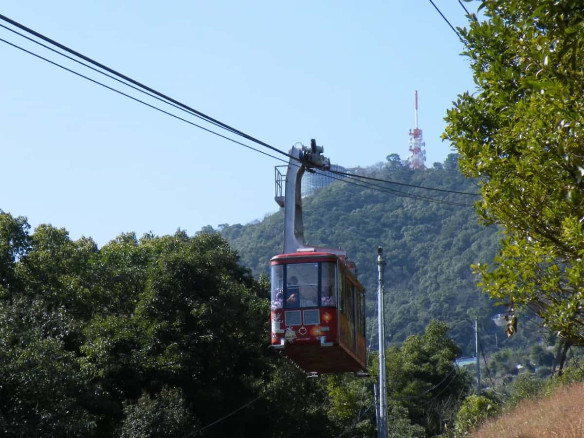 Une cabine rouge du téléphérique du mont Inasa au-dessus de la forêt, à Nagasaki