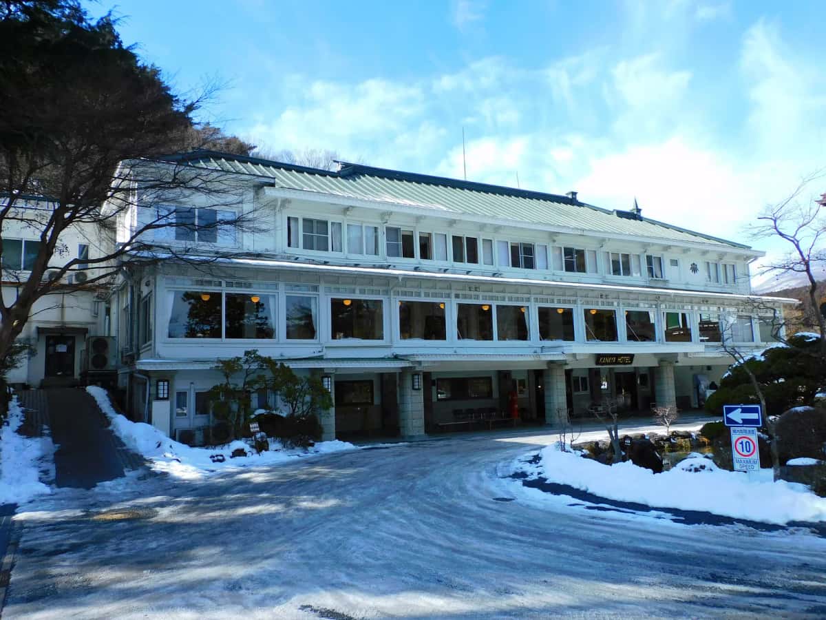 Le bâtiment principal blanc du Nikko Kanaya Hotel, avec ses fenêtres à l'occidentale et son toit vert, en hiver