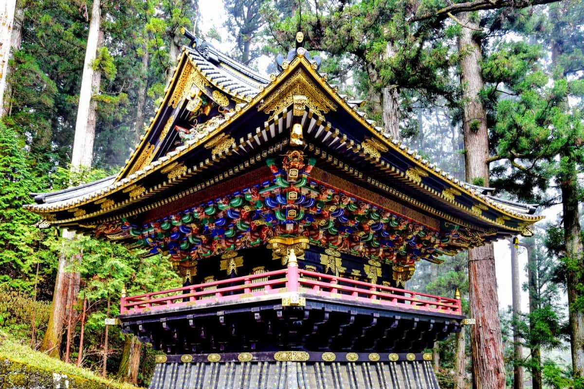 Tour laquée noir, rouge et or du Taiyūin de Nikko, entourée de grands cèdres