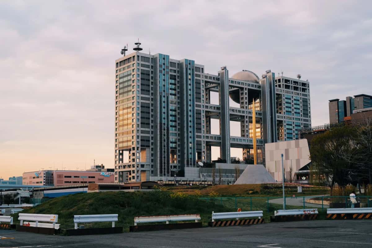 Le siège de Fuji TV à Odaiba, avec sa sphère d'observation en titane entre deux blocs de bureaux, au coucher du soleil