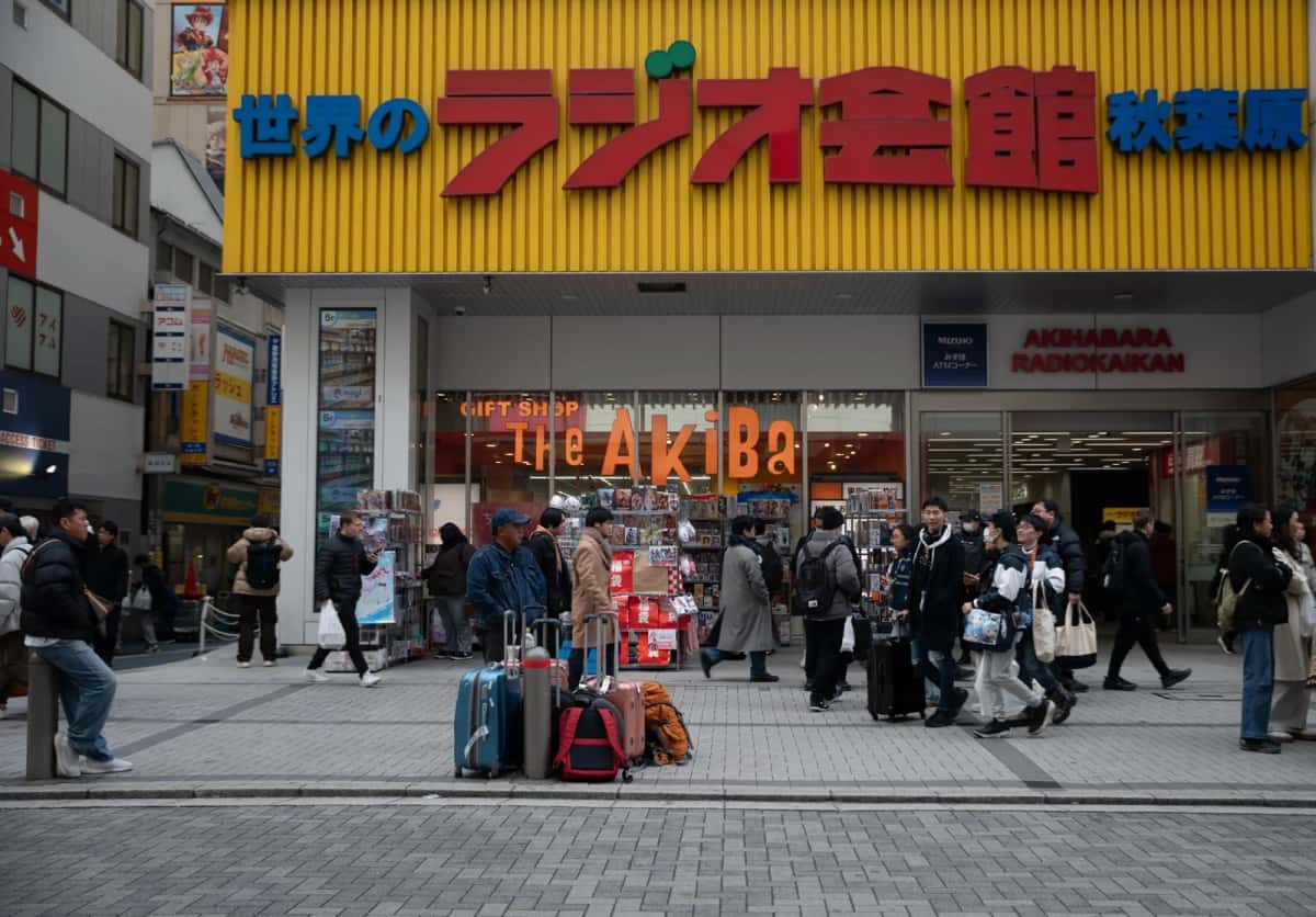 Voyageurs et valises devant le Radio Kaikan, immeuble de boutiques d'électronique d'Akihabara à Tokyo