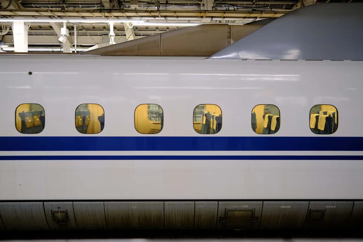Rame de Shinkansen à quai dans une gare japonaise, sièges visibles par les fenêtres