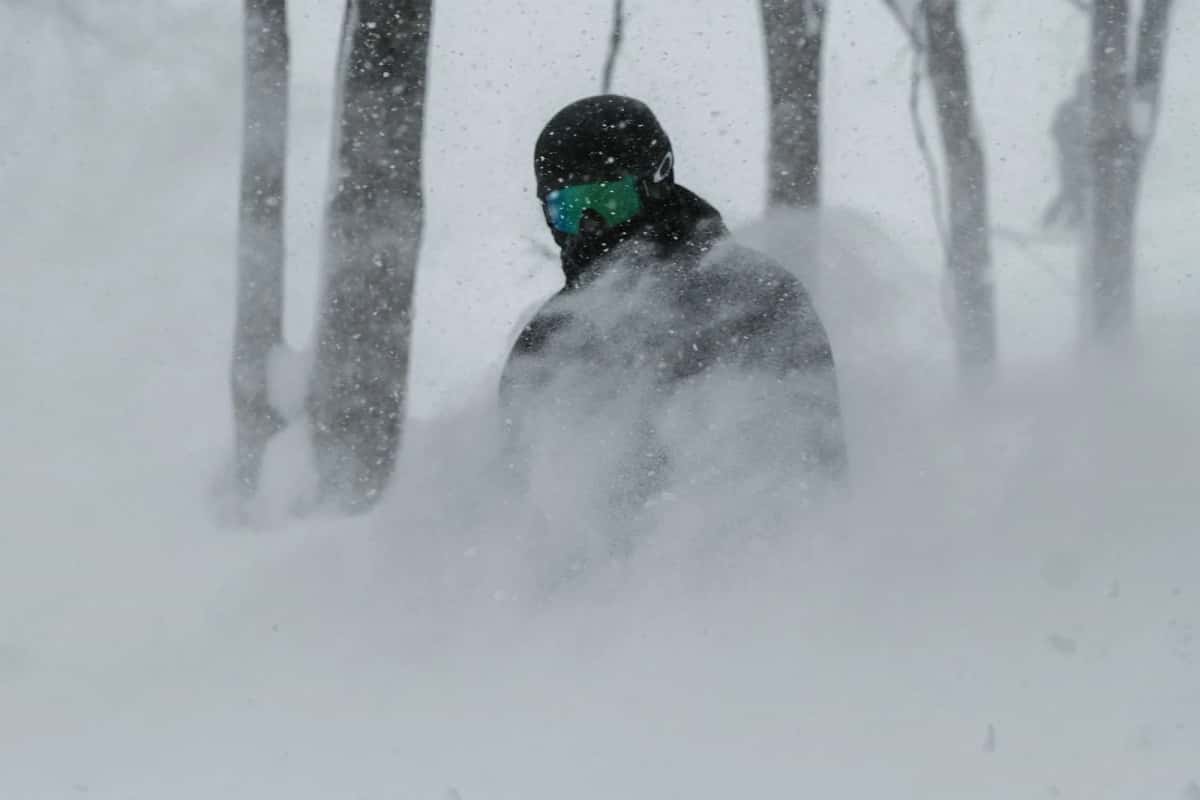 Snowboardeur dans la poudreuse d'une station de ski de Hokkaido