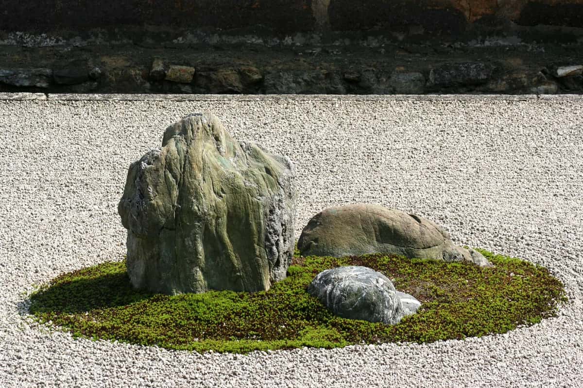 Gros plan sur un groupe de pierres posé sur la mousse dans le jardin sec du Ryoan-ji, Kyoto
