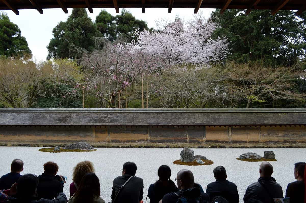 Visiteurs assis sur la véranda du Hojo face au jardin de pierres du Ryoan-ji, Kyoto
