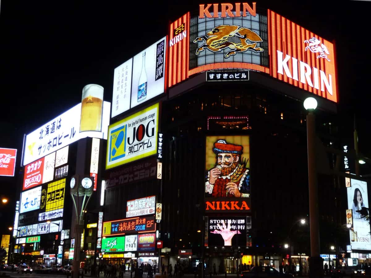 Le carrefour de Susukino à Sapporo la nuit, avec l'enseigne Nikka et les néons