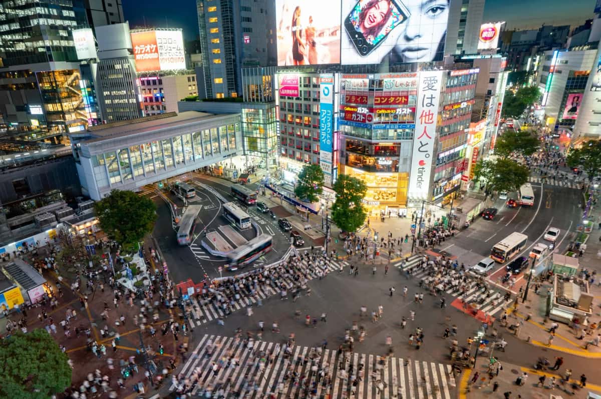 Vue plongeante sur le carrefour de Shibuya et ses foules en début de soirée