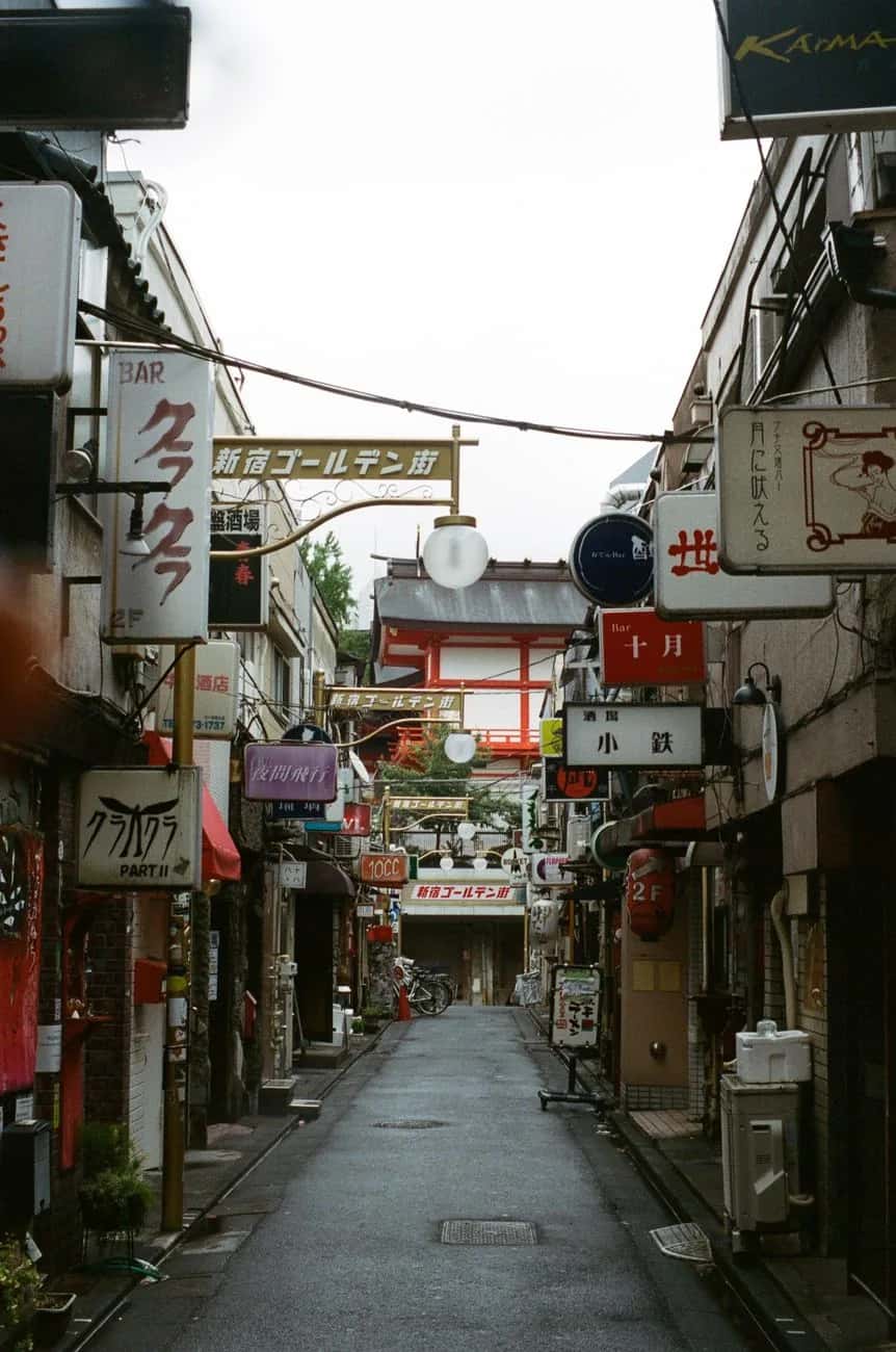 Ruelle du Golden Gai à Shinjuku de jour, bordée d'enseignes de bars sur deux étages