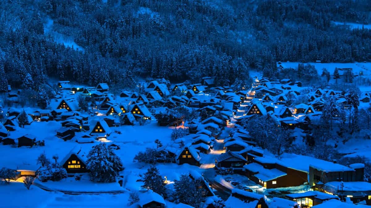 Le village de Shirakawa-go sous la neige, de nuit, ses fermes gassho éclairées pendant les illuminations d'hiver