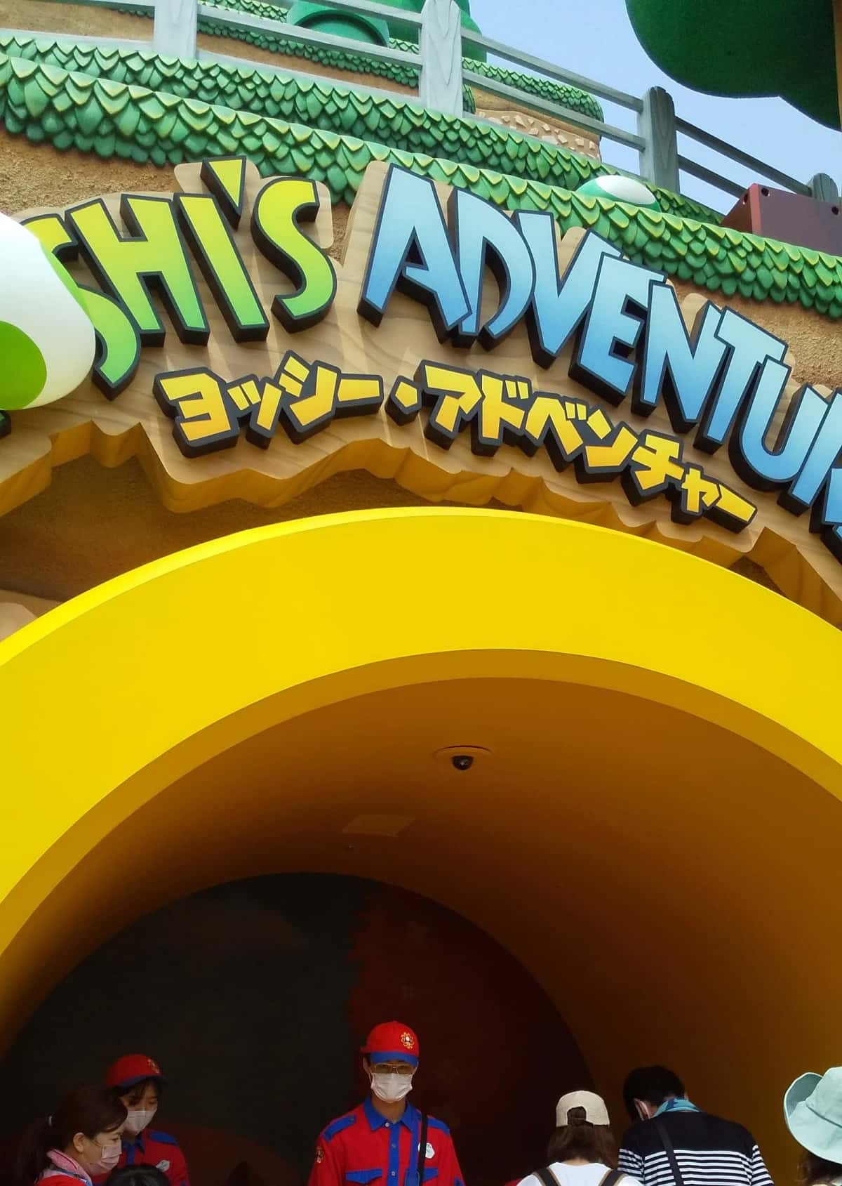 L'enseigne de Yoshi's Adventure en lettres vertes et jaunes au-dessus de l'entrée de l'attraction, à Osaka