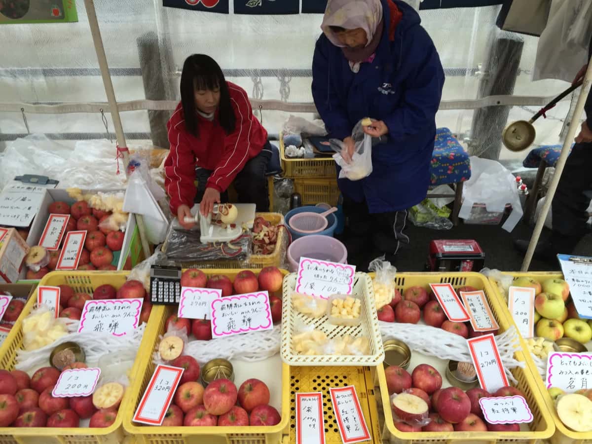 Étal de pommes de Hida et marchandes au marché du matin de Miyagawa, à Takayama