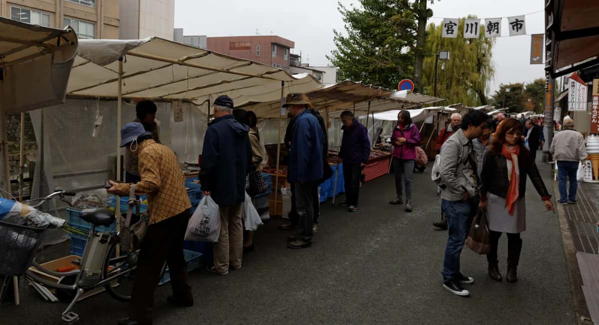 Étals sous auvents et clients au marché du matin de Miyagawa, à Takayama