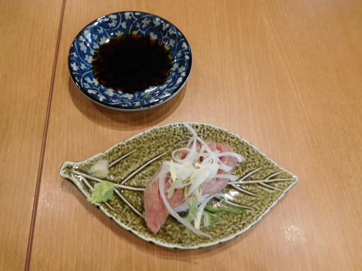 Nigiri de bœuf de Hida aux oignons, servi sur une assiette en forme de feuille à Takayama