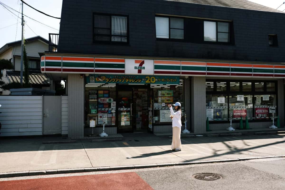 Façade d'un konbini 7-Eleven dans une rue résidentielle japonaise, où l'on peut déposer un colis Yamato