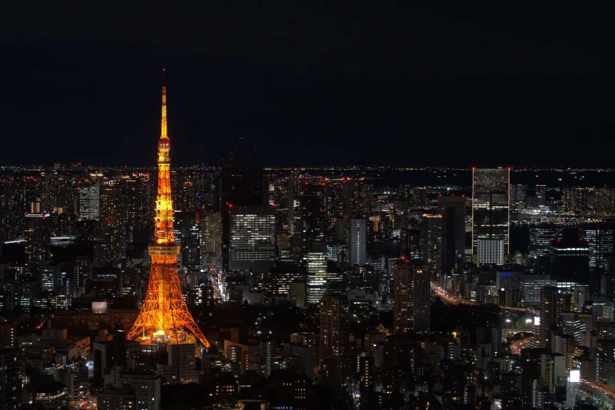 La Tokyo Tower illuminée en orange la nuit au milieu des immeubles de Minato