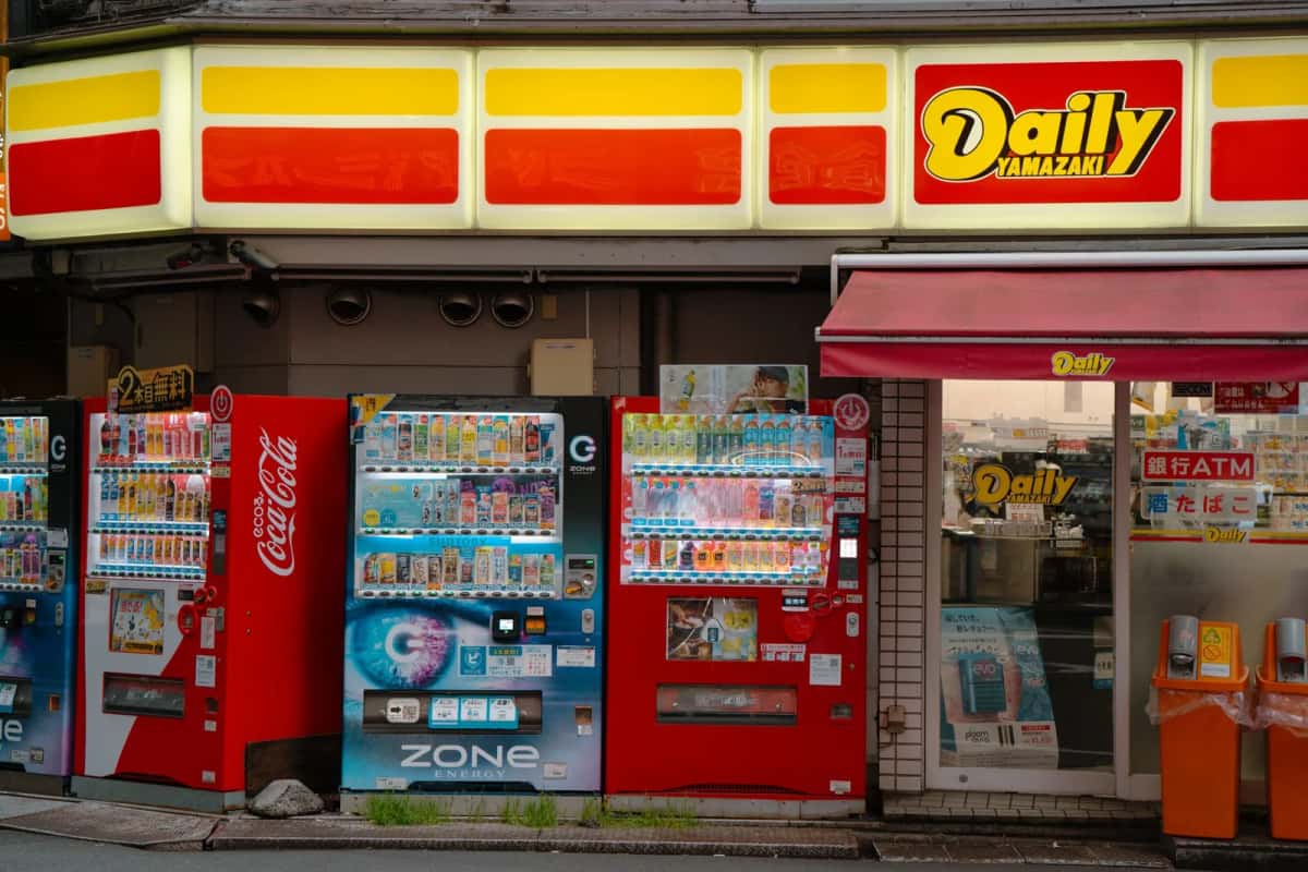 Devanture de konbini au Japon avec son enseigne de distributeur bancaire et ses machines à boissons